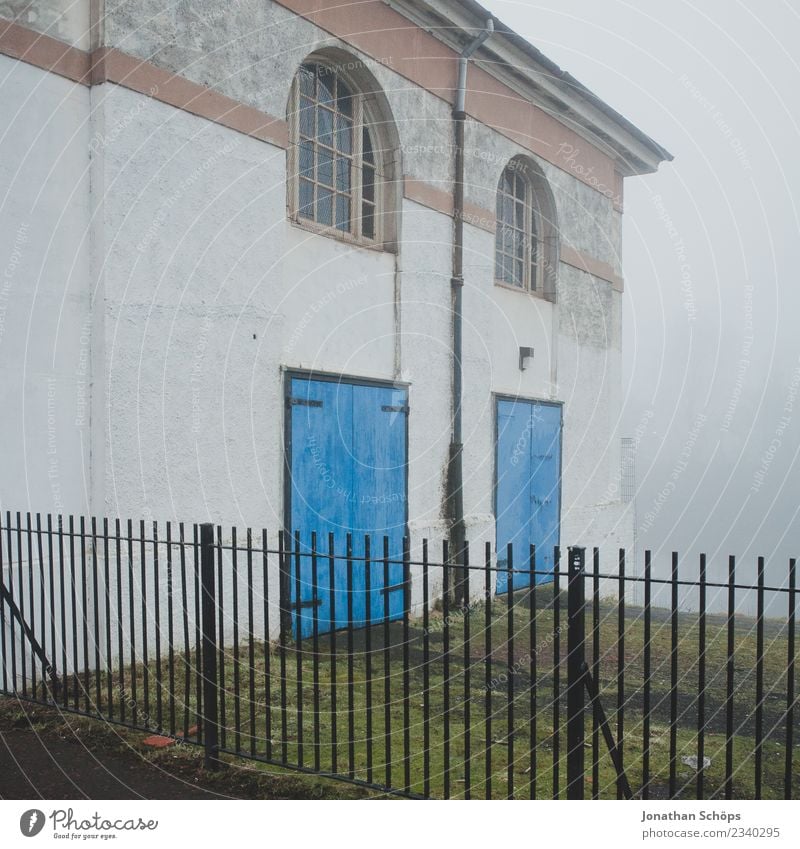 Haus im Nebel in Glasgow Stadt ästhetisch Nebelschleier Dunst Schottland Zaun Tür blau Fassade gruselig Nebelstimmung Nebellandschaft Farbfoto Außenaufnahme
