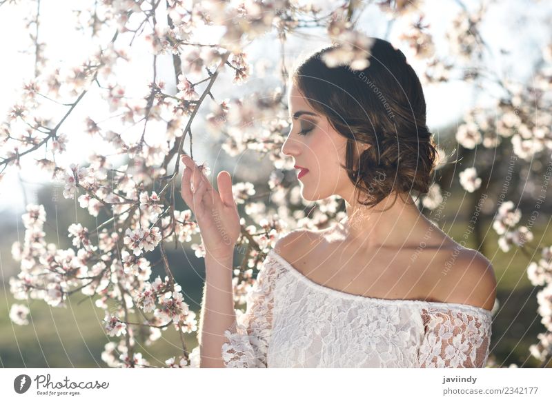Junge Frau zwischen den Mandeln blüht im Frühling. Stil schön Gesicht Mensch feminin Jugendliche Erwachsene 1 18-30 Jahre Natur Baum Blume Blüte Park Mode Kleid