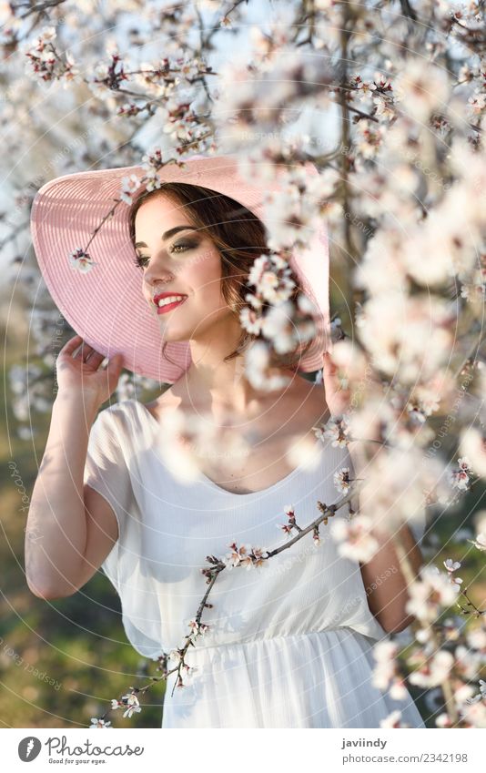 Junge Frau auf einem mandelblühenden Feld im Frühjahr Stil schön Mensch feminin Jugendliche Erwachsene 1 18-30 Jahre Natur Baum Blume Blüte Mode Kleid Hut