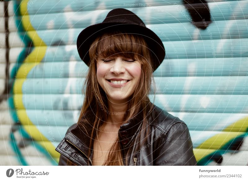 Frau mit Hut vor Graffiti lacht mit geschlossenen Augen Mensch feminin Erwachsene 1 30-45 Jahre Lächeln lachen Glück Fröhlichkeit Zufriedenheit selbstbewußt