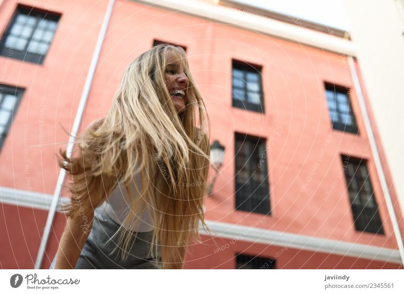 Glückliche junge Frau mit beweglichen Haaren im urbanen Hintergrund schön Haare & Frisuren Sommer Mensch feminin Junge Frau Jugendliche Erwachsene 1 18-30 Jahre