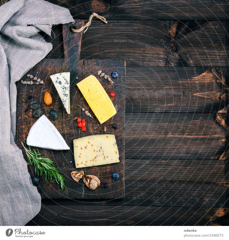 Stücke von verschiedenen Käsesorten Tisch Holz alt Essen blau gelb weiß Holzplatte Brie roquefort Cheddar Verschiedenheit Lebensmittel Mahlzeit Snack