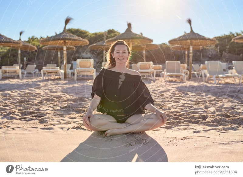 Lächelnde Barfuß-Frau am Strand sitzend Glück Erholung Meditation Freizeit & Hobby Ferien & Urlaub & Reisen Sommer Yoga Erwachsene 1 Mensch 45-60 Jahre Sand