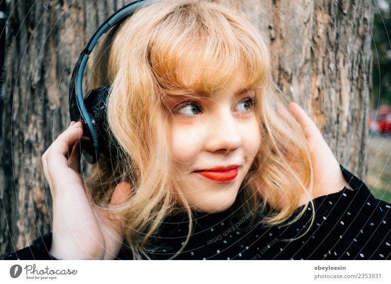 Junges hübsches Mädchen, das Spaß daran hat, Musik über Kopfhörer zu hören, Lifestyle Stil Freude Glück schön Erholung Freizeit & Hobby Sommer Telefon