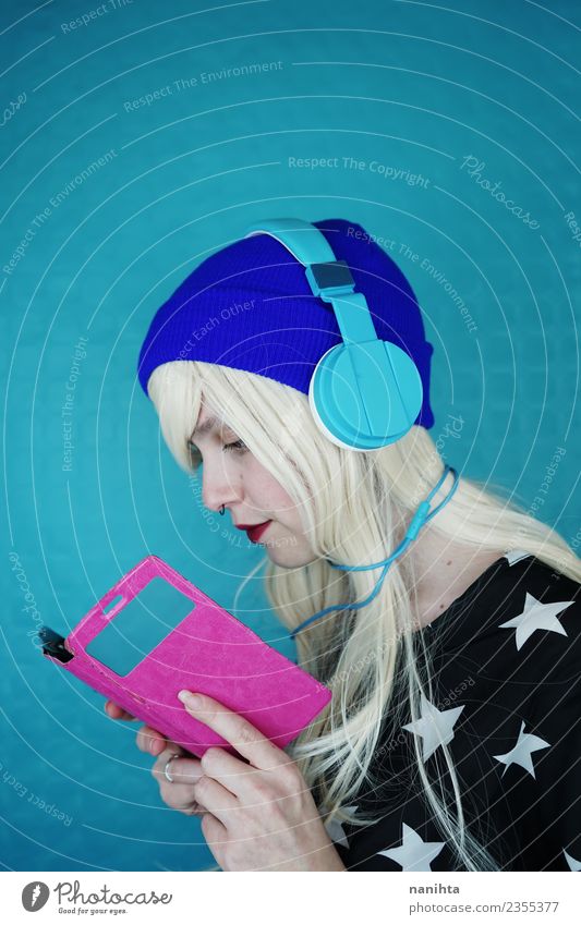 Junge Frau beim Lesen und Musikhören mit ihrem Handy Lifestyle Stil Haare & Frisuren Freizeit & Hobby Headset Kabel Technik & Technologie