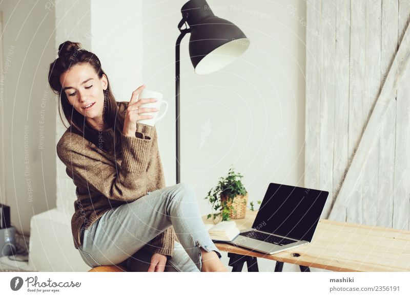 junge schöne Frau zu Hause Kaffee Lifestyle Freude Erholung Telefon Computer Notebook Technik & Technologie Internet Erwachsene sitzen modern heimwärts