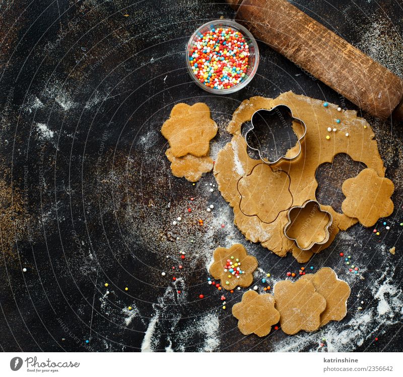 Kekse mit Keksausstechern auf einem dunklen Tisch zubereiten. Teigwaren Backwaren Dessert Küche Blume Metall machen oben braun Tradition backen Bäckerei Biskuit