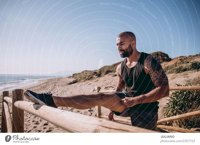 zäher muskulöser Mann streckt sich am Geländer zum Strand. Junger Mann Sport Training Fitness Sport-Training hart transpirieren Muskulatur Freude Sportler