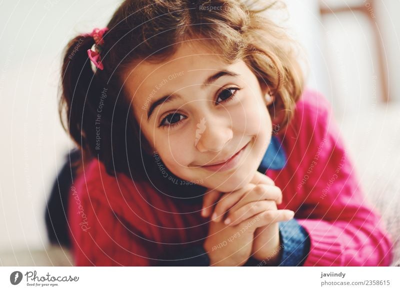 Liebenswertes kleines Mädchen mit süßem Lächeln, das auf dem Bett liegt. Freude Glück schön Gesicht Kind Mensch Frau Erwachsene Kindheit 1 3-8 Jahre niedlich