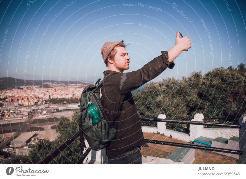 Junger Mann nimmt Selfie an der Spitze der Stadt. Abenddämmerung Gefühle Glück Leben Lifestyle Sommer Sonne Sonnenuntergang Jugendliche Abenteuer Freiheit
