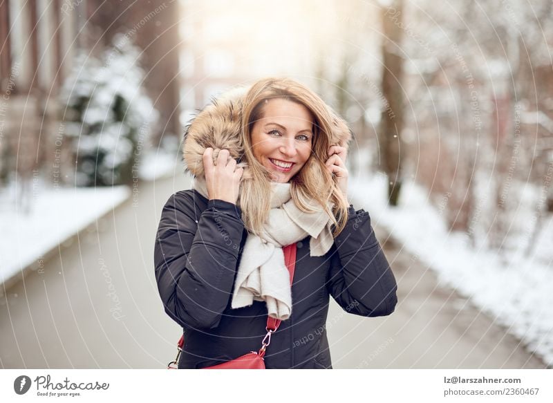 Freundliche junge blonde Frau im Winter im Freien Lifestyle Glück schön Gesicht Schnee Erwachsene 1 Mensch 45-60 Jahre Park Straße Mode Mantel Pelzmantel Schal