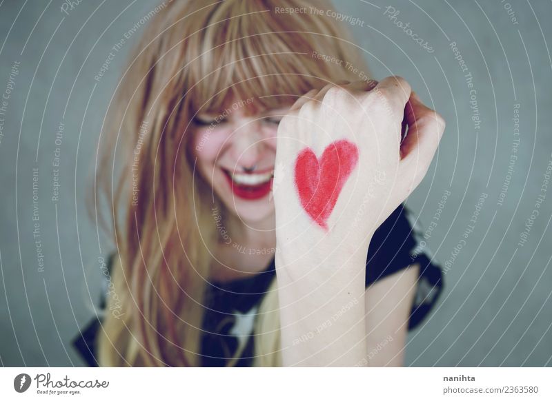 Fröhliche junge Frau mit einem roten Herzen in der Hand. Lifestyle Stil Design Freude Glück Haare & Frisuren Wellness Leben Mensch feminin Junge Frau