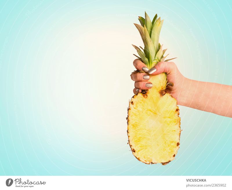 Hand mit Hälfte der Ananas auf blauem Hintergrund Lebensmittel Frucht Stil Design Freude Gesunde Ernährung Ferien & Urlaub & Reisen Sommer feminin tropisch
