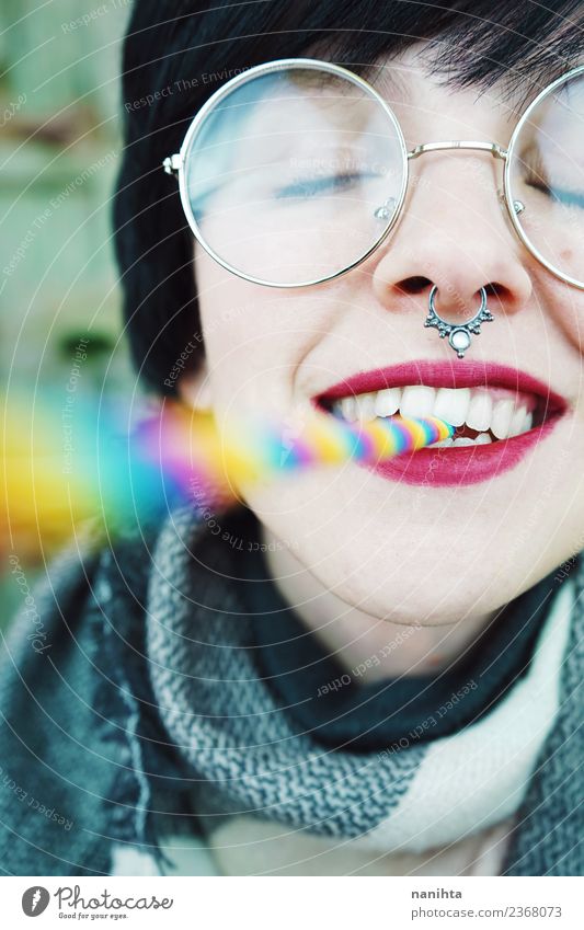 Junge und glückliche Frau mit einem Regenbogenstrohhalm im Mund. Lifestyle Stil exotisch Freude schön Haare & Frisuren Haut Gesicht Wellness Leben