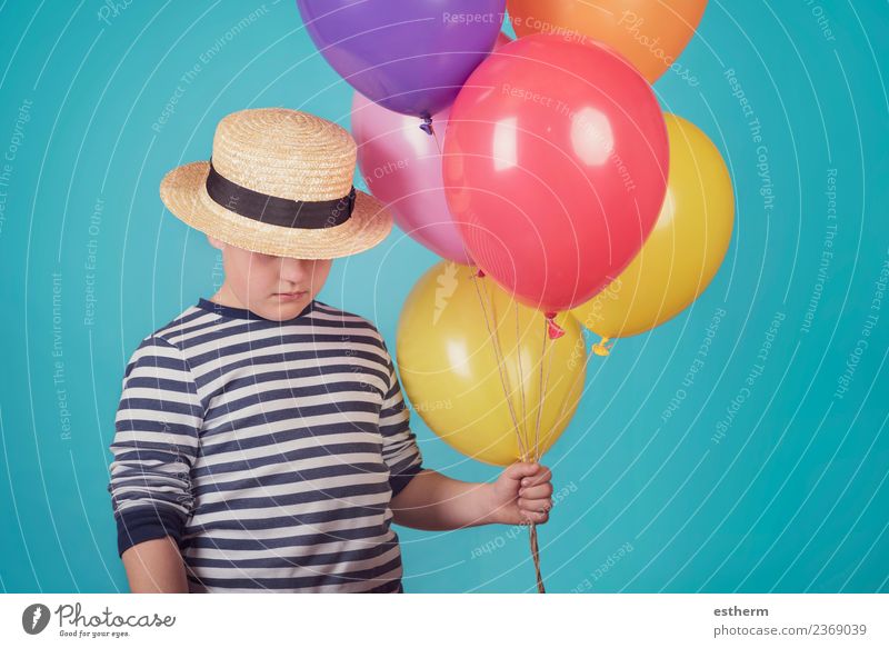 nachdenklicher Junge mit Ballons auf blauem Hintergrund Lifestyle Mensch maskulin Kind Kleinkind Kindheit 1 8-13 Jahre Hut Luftballon Denken Fitness kuschlig