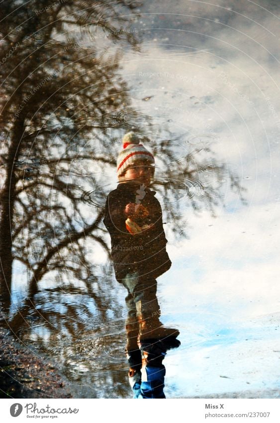 Pfütze Mensch Kind Kleinkind Kindheit 1 1-3 Jahre Wasser Wetter schlechtes Wetter Straße Wege & Pfade dreckig kalt nass hüpfen matschen Farbfoto Außenaufnahme