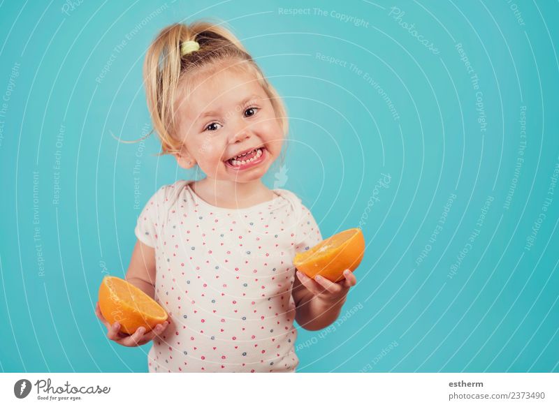 lächelndes Baby mit einer Orange auf blauem Hintergrund Lebensmittel Frucht Ernährung Essen Lifestyle Freude Mensch feminin Mädchen Kindheit 1 3-8 Jahre Fressen