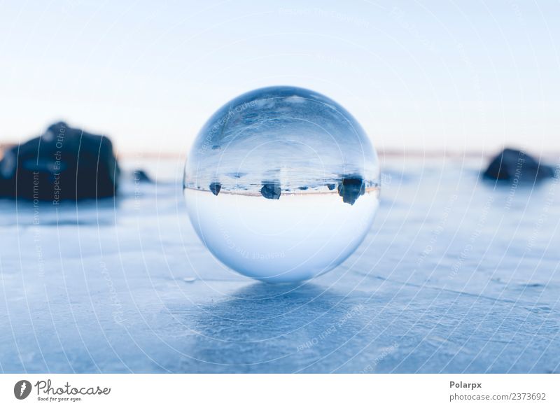 Glaskugel, die auf Eis auf einem gefrorenen See balanciert. Design schön Wellness Meditation Winter Schnee Berge u. Gebirge Dekoration & Verzierung Natur