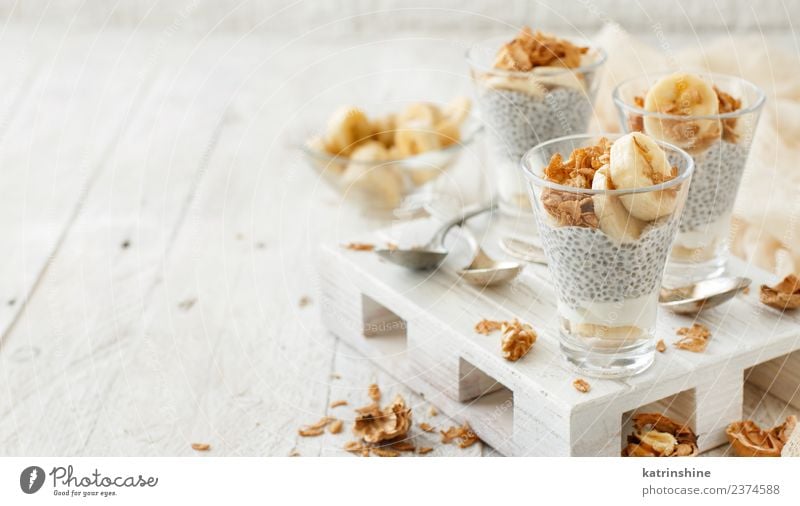 Chiapudding-Parfait, überzogen mit Banane und Granola Joghurt Frucht Dessert Essen Frühstück Diät Schalen & Schüsseln Löffel weiß Müsli Pudding Samen Molkerei