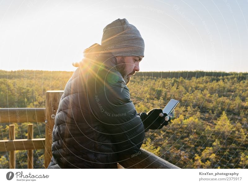 Bartiger Mann betrachtet Smartphone gegen den Wald Lifestyle Freizeit & Hobby Ferien & Urlaub & Reisen Tourismus Telefon PDA Fotokamera Technik & Technologie