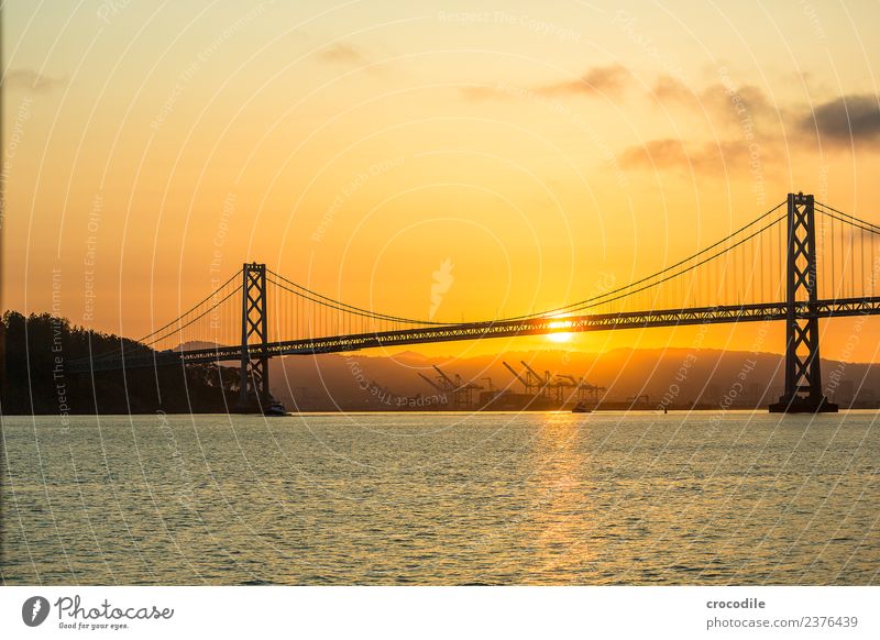 # 751 Oakland Bay Bridge San Francisco Hafen Meer Sonnenaufgang Anlegestelle Brücke ruhig Gegenlicht Farbfoto orange Licht Hängebrücke Einsamkeit Kran