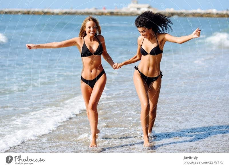 Zwei junge Frauen im Bikini an einem tropischen Strand. Lifestyle Freude Glück schön Körper Haare & Frisuren Freizeit & Hobby Ferien & Urlaub & Reisen Tourismus