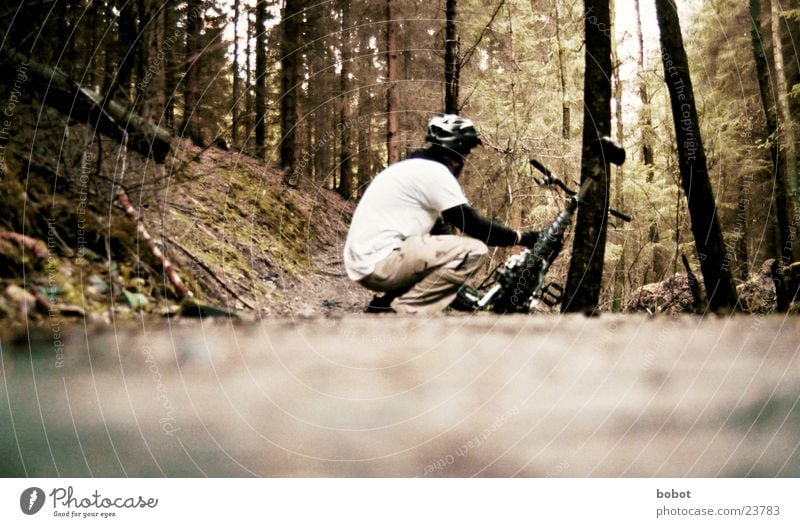 Ein Biker hockt im Walde ganz still und stumm ... Mountainbike Fahrrad Blatt Holz Baumrinde transpirieren Ausdauer Suspension hocken Helm Verkehr
