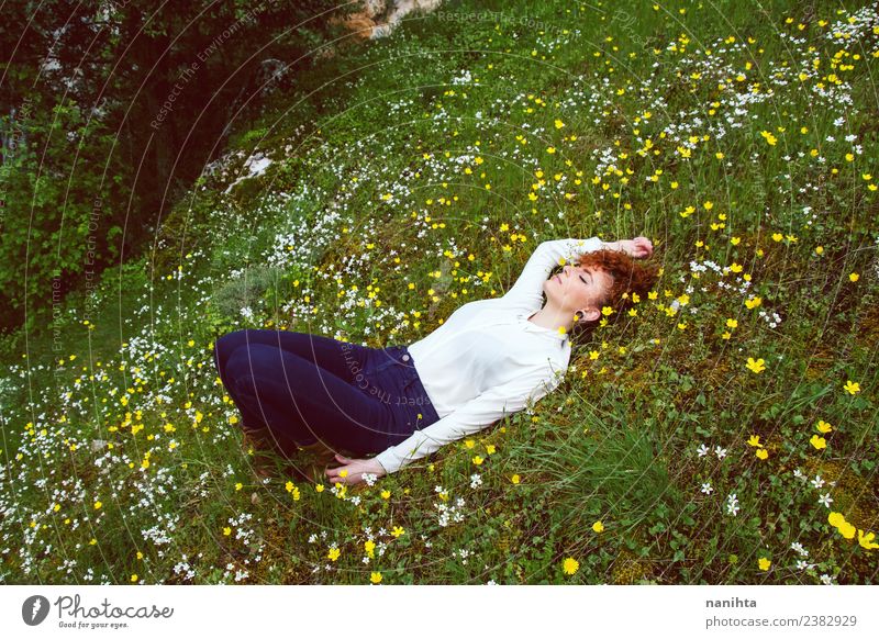 Junge Frau, die sich auf einem Blumenfeld ausruht. Lifestyle Freude Gesundheit Wellness harmonisch Sinnesorgane Erholung ruhig Meditation