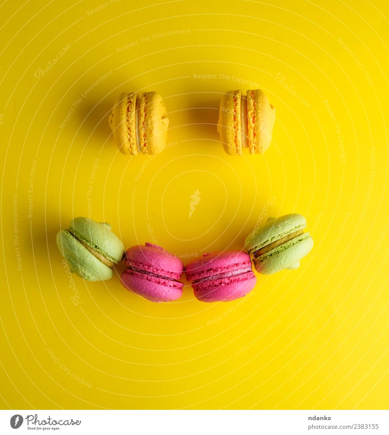 mehrfarbiges Backgebäck mit Mandelmehl Dessert Süßwaren Lächeln hell gelb grün rosa Farbe Tradition Macaron Backwaren Sortiment Hintergrund backen Bäckerei