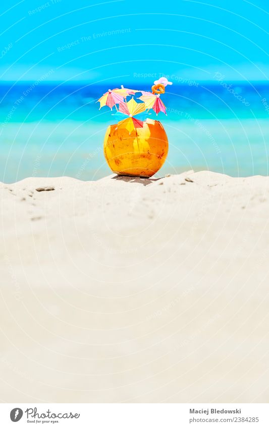 Kokosnuss mit bunten Regenschirmen und Strohhalmen am Strand. Frucht Getränk Erfrischungsgetränk Lifestyle Reichtum Freude Erholung Ferien & Urlaub & Reisen