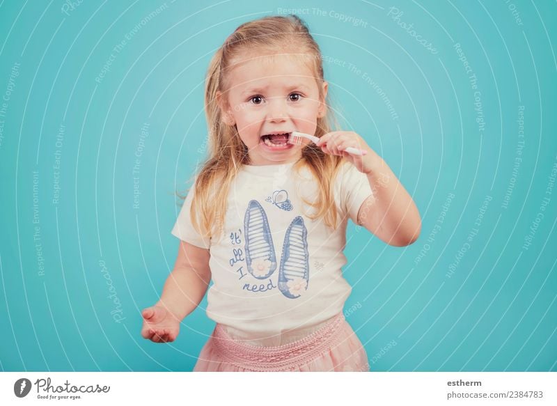 kleines Mädchen mit Zahnbürste auf blauem Hintergrund Lifestyle Freude Körperpflege Gesundheitswesen Mensch feminin Baby Kindheit 1 3-8 Jahre festhalten Fitness