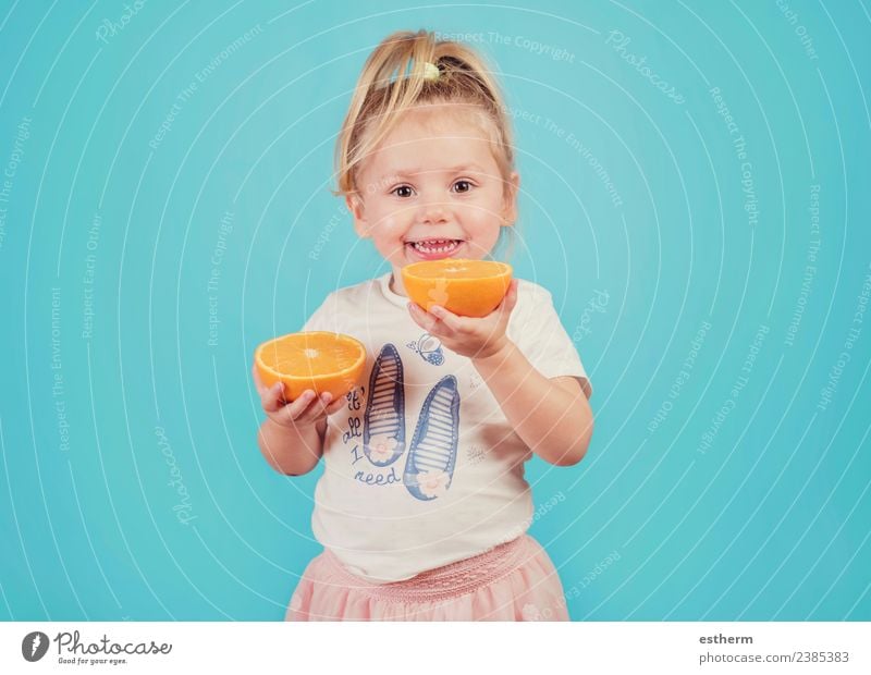 lächelndes Baby mit einer Orange auf blauem Hintergrund Lebensmittel Frucht Ernährung Essen Mittagessen Freude Gesunde Ernährung Mensch feminin Mädchen Kindheit