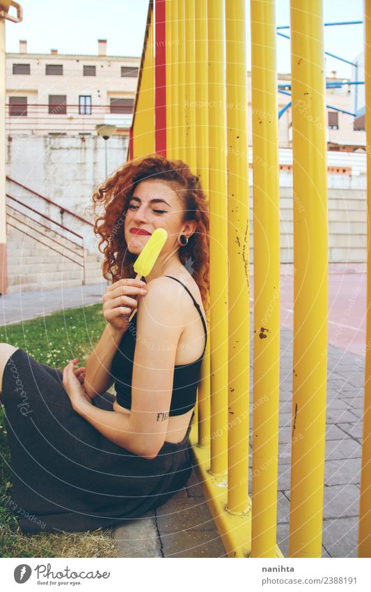 Junge glückliche Frau mit einem Zitronen-Eis-Pop Lebensmittel Speiseeis Lifestyle Stil Freude Wellness Sommer Sommerurlaub Mensch feminin Junge Frau Jugendliche