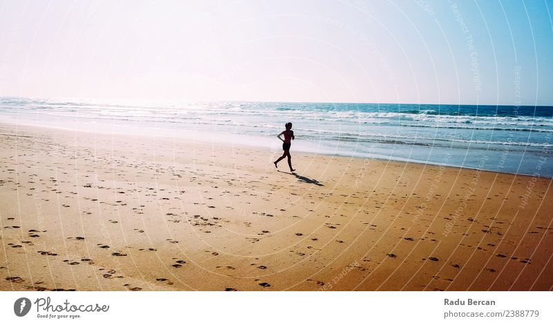 Luftaufnahme der sportlichen Frau, die am Strand läuft. Gesundheit Fitness Leben Abenteuer Sommer Sonne Meer Sport Sport-Training Leichtathletik Joggen Mensch