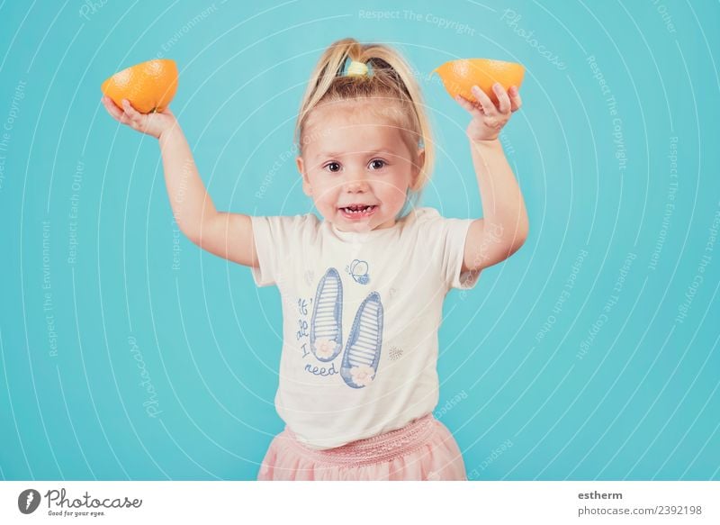lächelndes Baby mit einer Orange auf blauem Hintergrund Lebensmittel Frucht Ernährung Essen Mittagessen Lifestyle Freude Gesunde Ernährung Mensch feminin