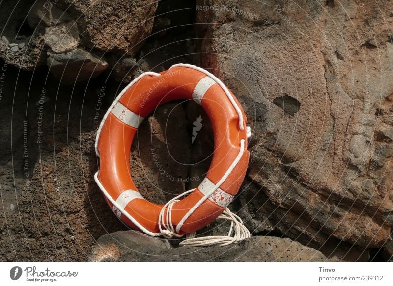 oranger Rettungsring vor Felsen braun weiß Rettungsgeräte Seil Überleben Kreis rund Menschenleer Felswand 1 Farbfoto Außenaufnahme Textfreiraum links