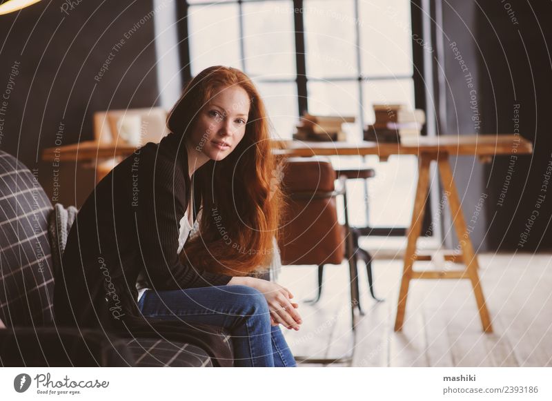 junge Lesekopf-Frau, die sich zu Hause entspannt. Tee Lifestyle Erholung stricken Stuhl Tisch Erwachsene Herbst Wärme Pullover rothaarig Holz Metall träumen