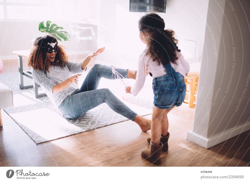 Mutter und Tochter spielen im Wohnzimmer mit Kostümen Freude Glück Spielen Kind Eltern Erwachsene Familie & Verwandtschaft Kindheit lachen Fröhlichkeit