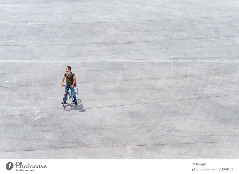 Junger Mann steht mit seinem Fahrrad auf einem Platz. Lifestyle Leben Ferien & Urlaub & Reisen Tourismus Mensch maskulin Jugendliche Erwachsene 1 30-45 Jahre
