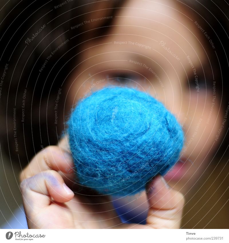 Kind hält blauen Filzball in der Hand Handarbeit Gesicht Finger 8-13 Jahre Kindheit Kunst Textilien Wolle Kugel rund haltend Erde Knäuel Wollknäuel zeigen