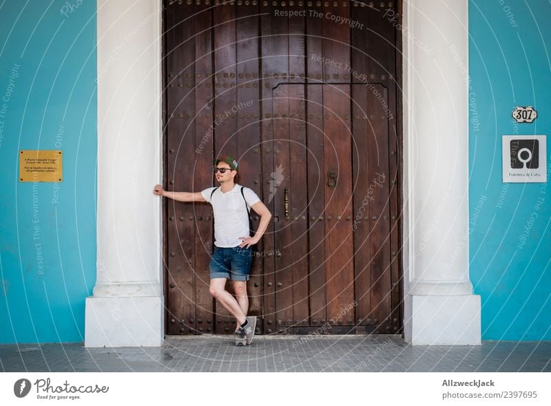junger Mann wartet an einer Holztür und stützt sich ab Kuba Havanna Insel Ferien & Urlaub & Reisen Reisefotografie Ausflug Sightseeing Straße Stadt blau Fernweh
