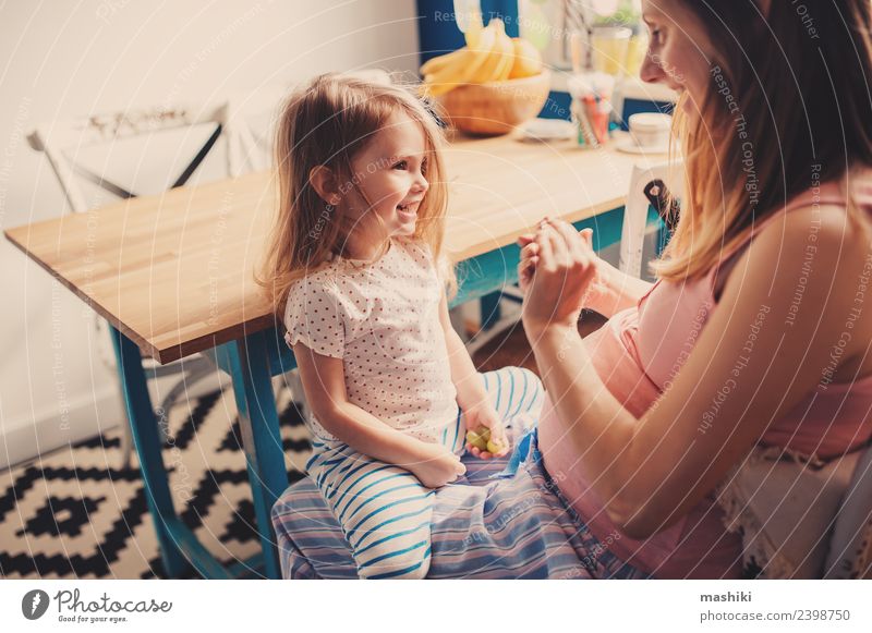 Kleinkind Mädchen spielt mit schwangerer Mutter zu Hause. Frühstück Tee Freude Spielen Tisch Küche Kind Baby Eltern Erwachsene Familie & Verwandtschaft blond