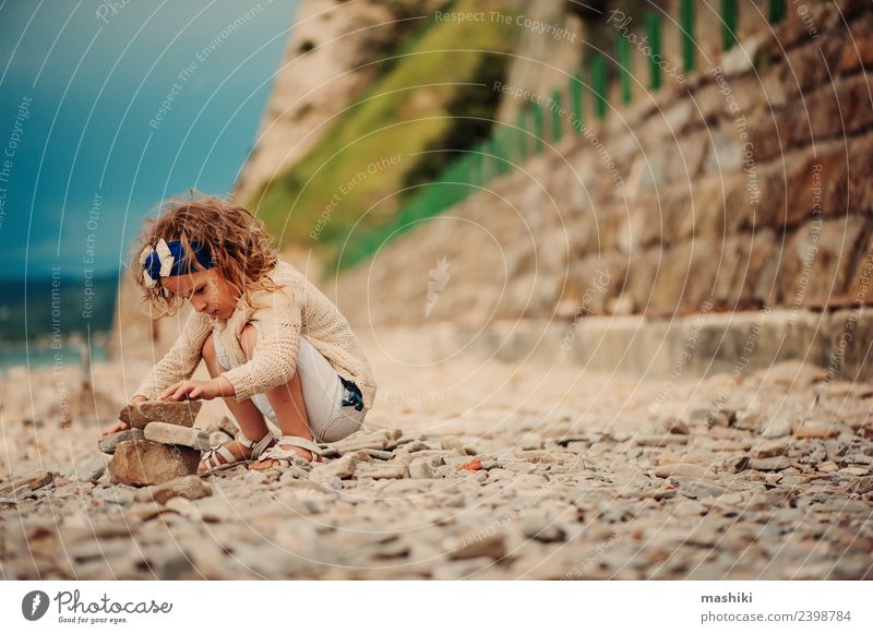 Kind Mädchen spielt mit Steinen am Strand Freude Glück schön Spielen Ferien & Urlaub & Reisen Sommer Meer Himmel Küste Lächeln sitzen klein niedlich blau weiß