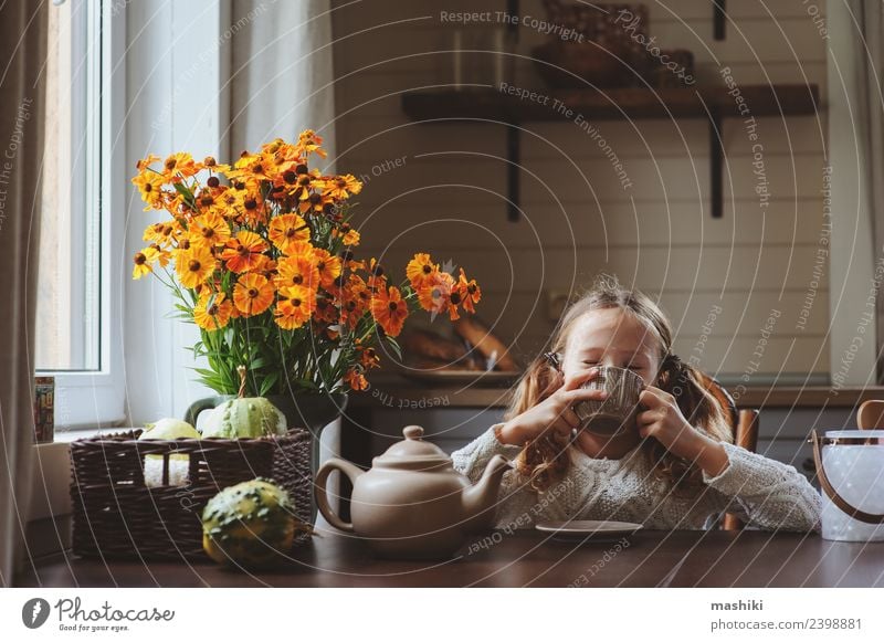 Kind Mädchen beim Frühstück zu Hause Tee Lifestyle Glück Dekoration & Verzierung Stuhl Tisch Küche Familie & Verwandtschaft Herbst Wärme Blume sitzen modern