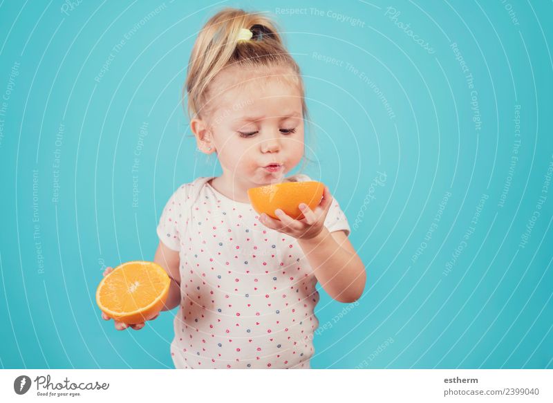 Baby isst eine Orange auf blauem Hintergrund Lebensmittel Frucht Ernährung Essen Frühstück Mittagessen Mensch feminin Mädchen Kindheit 1 3-8 Jahre Diät