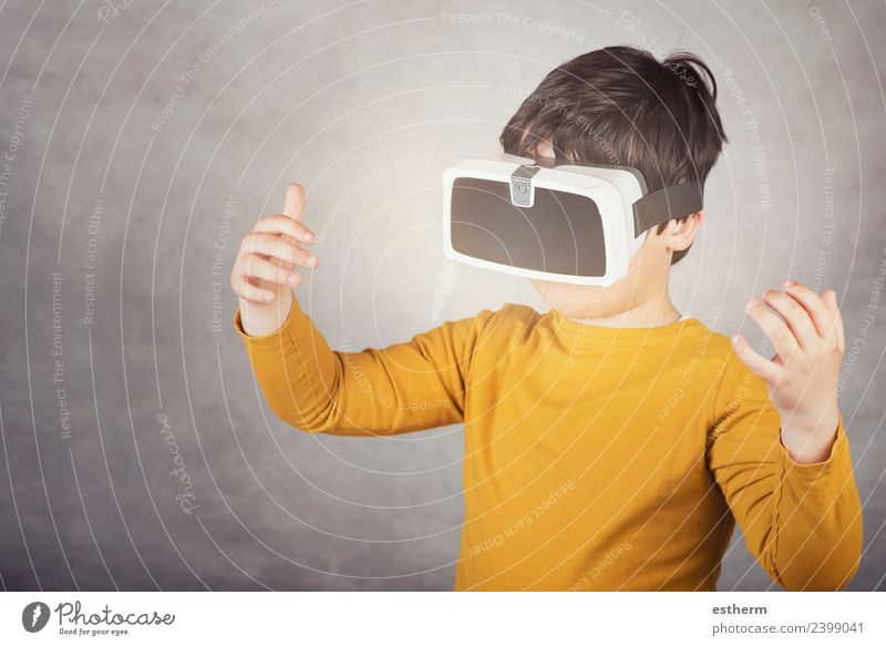 Junge spielt mit einer Virtual-Reality-Brille auf grauem Hintergrund Lifestyle Freude Spielen Hardware Technik & Technologie Unterhaltungselektronik