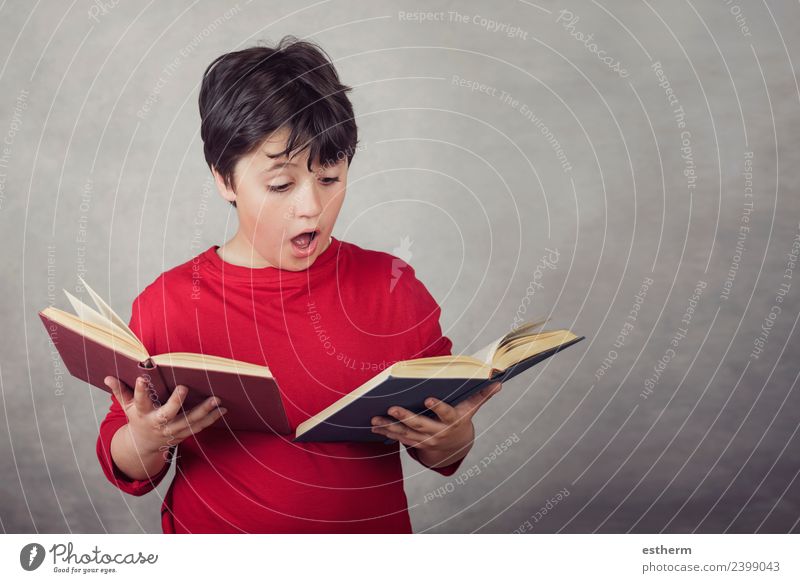 Junge liest Bücher auf grauem Hintergrund Lifestyle Freude lesen Bildung lernen Schulkind Prüfung & Examen Mensch maskulin Kind Kindheit 1 8-13 Jahre festhalten