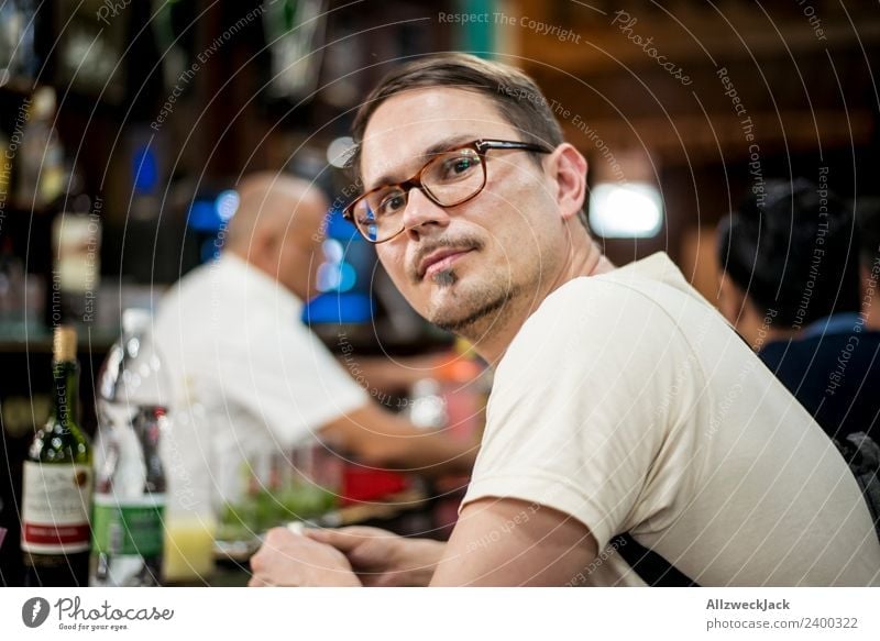 Portrait junger mann mit Brille an einer Bar Kuba Havanna Junger Mann Brillenträger Blick nach vorn Zufriedenheit verträumt träumen nachdenklich beobachten