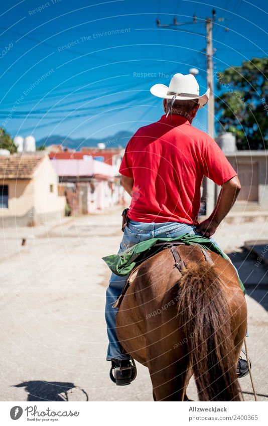 Mann auf einem Pferd reitet durch Trinidad in Kuba Sozialismus alt historisch retro old-school altmodisch Außenaufnahme Tag Sommer Sonne Blauer Himmel Wärme