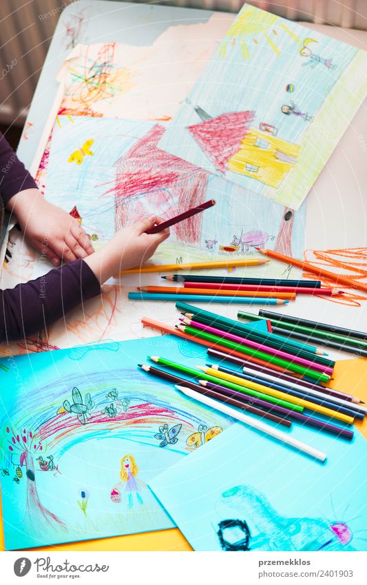 Kreiden, die auf dem Schreibtisch verstreut sind, gefüllt mit bunten Zeichnungen. Lifestyle Freude Glück Handarbeit Tisch Bildung Kindergarten Schule Mädchen 1
